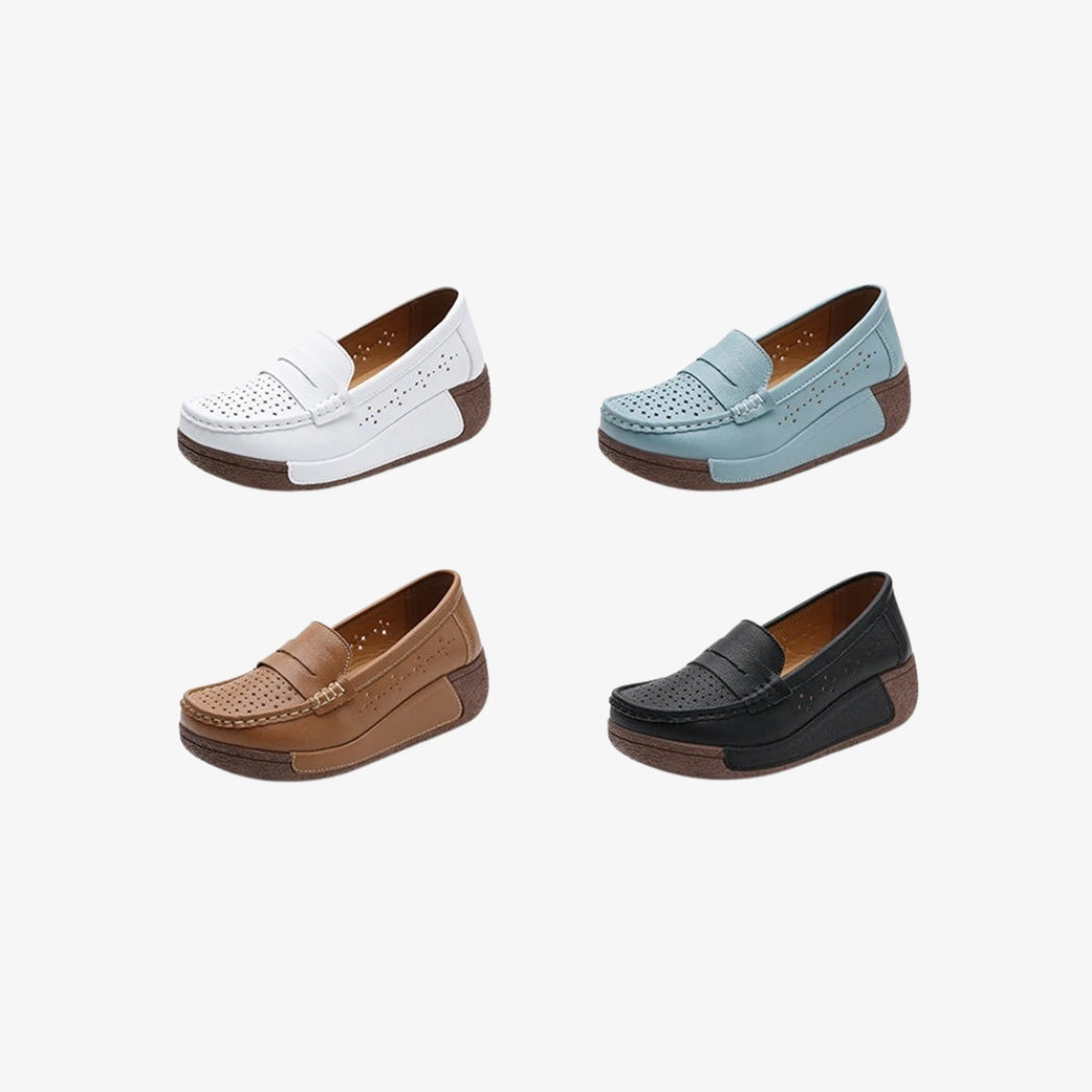 Perforerade loafers med kilklack för dam i läder, tillgängliga i flera färger: vit, blå, brun och svart. Dessa eleganta skor förenar komfort och stil med sin tjocka, texturerade bruna sula och luftiga design med dekorativa perforeringar. Perfekta för daglig användning.