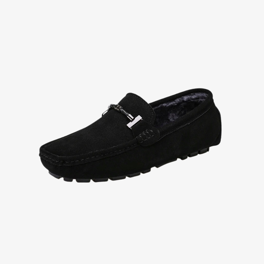 Loafers i svart mocka för herr, fodrade med mjukt material för extra komfort. Den klassiska designen lyfts av ett silverfärgat metallspänne på ovandelen. Den räfflade sulan ger bra grepp och förenar stil och funktion.