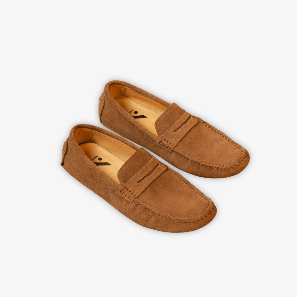 Brun Classico-loafer på golvet mot beige bakgrund