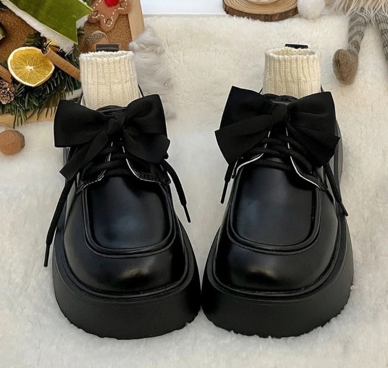 Svarta loafers med flugrosett och tjock sula