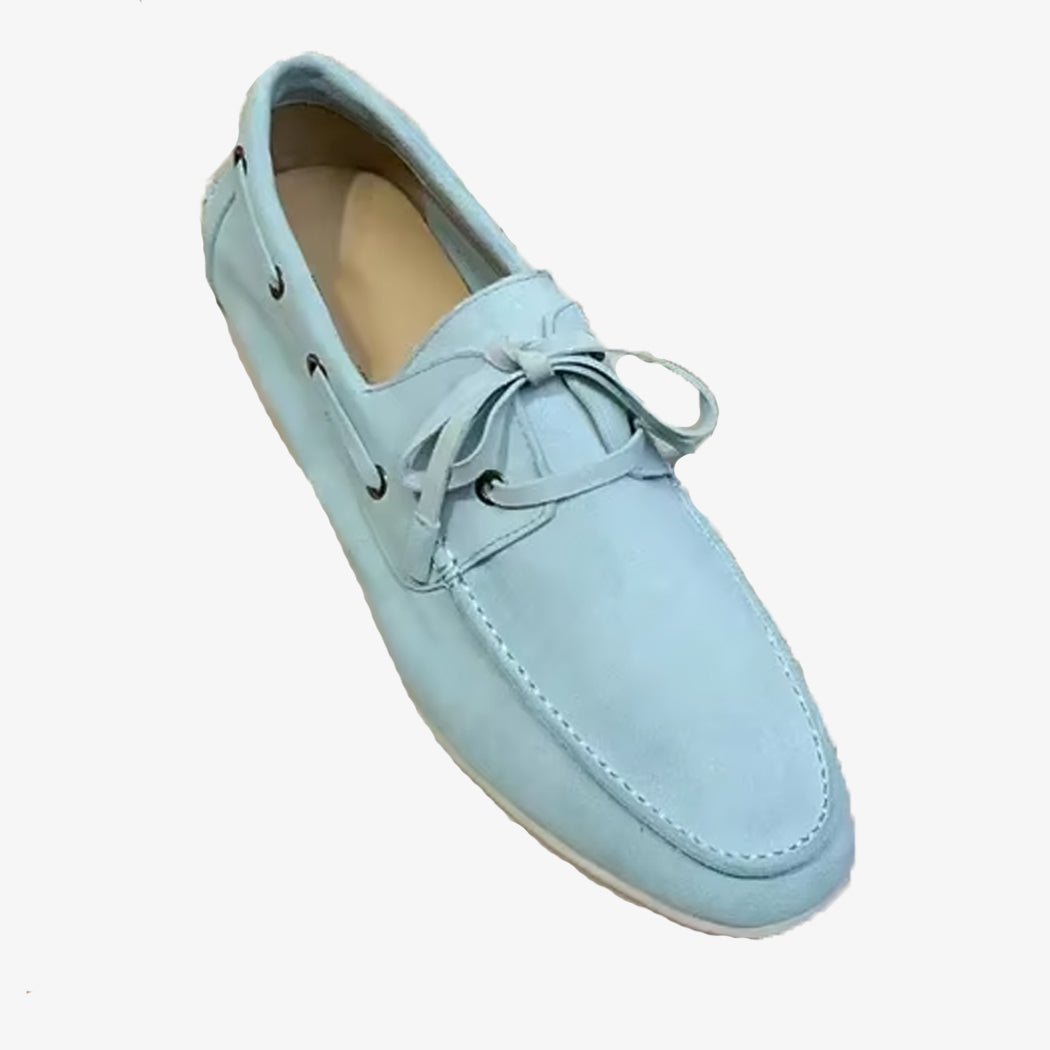 En elegant seglarloafer i ljusblå mocka mot vit bakgrund