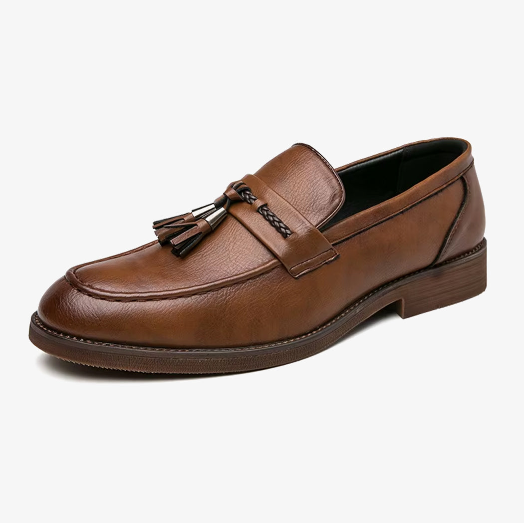 En elegant brun läderloafers med tofs för herr mot vit bakgrund