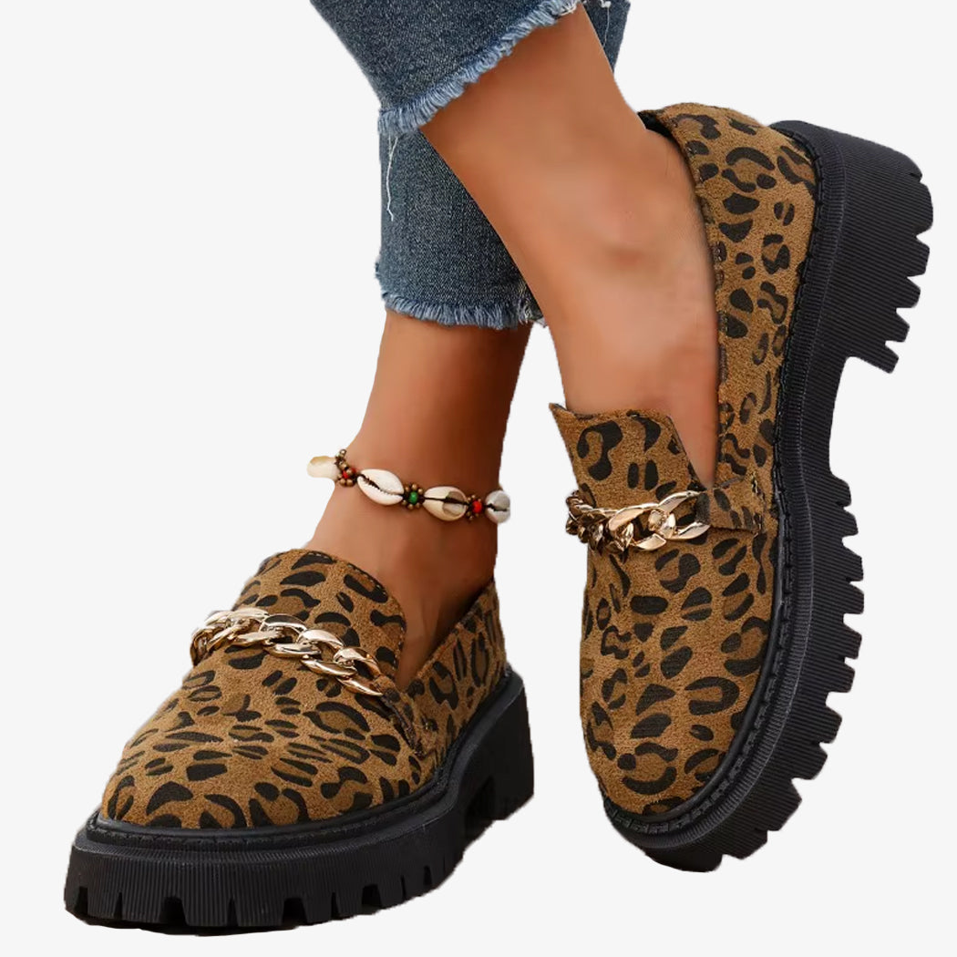 Par loafers i leopardmönstrad mocka med platåsula och kedja, burna med jeans och ett snäckarmband vid fotleden