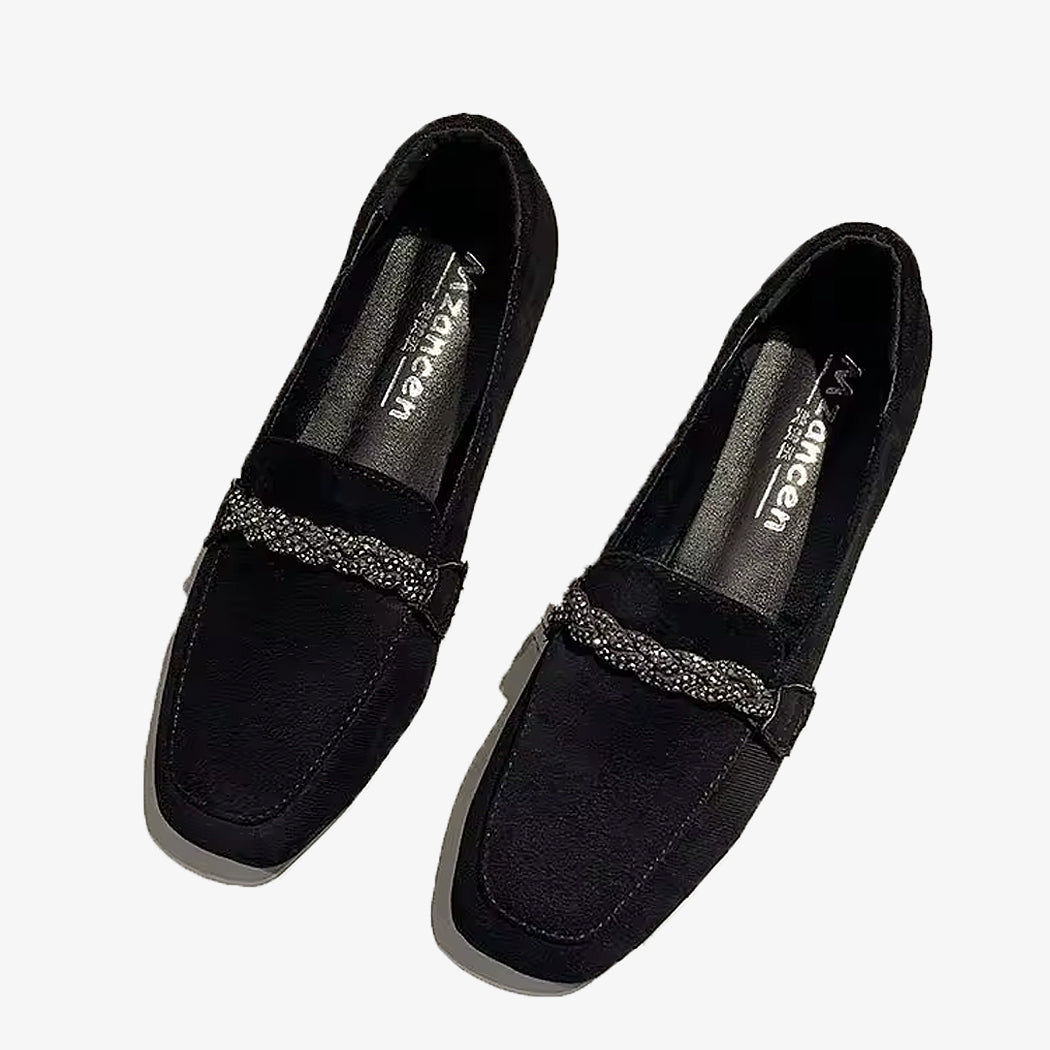 Svarta loafers i mocka med strass-kedja på vit bakgrund