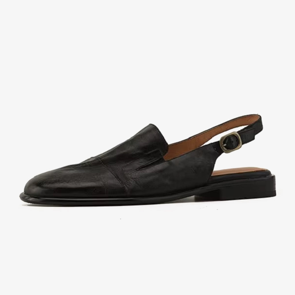 Bild på en svart loafer mule i läder för kvinnor, sedd från sidan