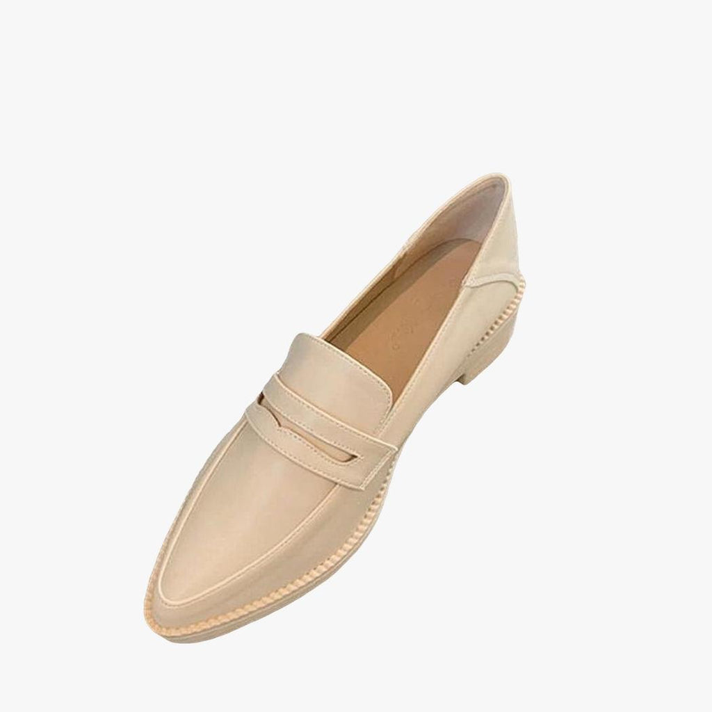 På ljusgrå bakgrund syns en beige loafer med spetsig tå och sula i regenererat läder