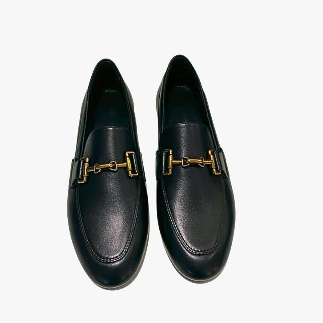på en vit bakgrund syns ett par svarta loafers för dam i äkta läder