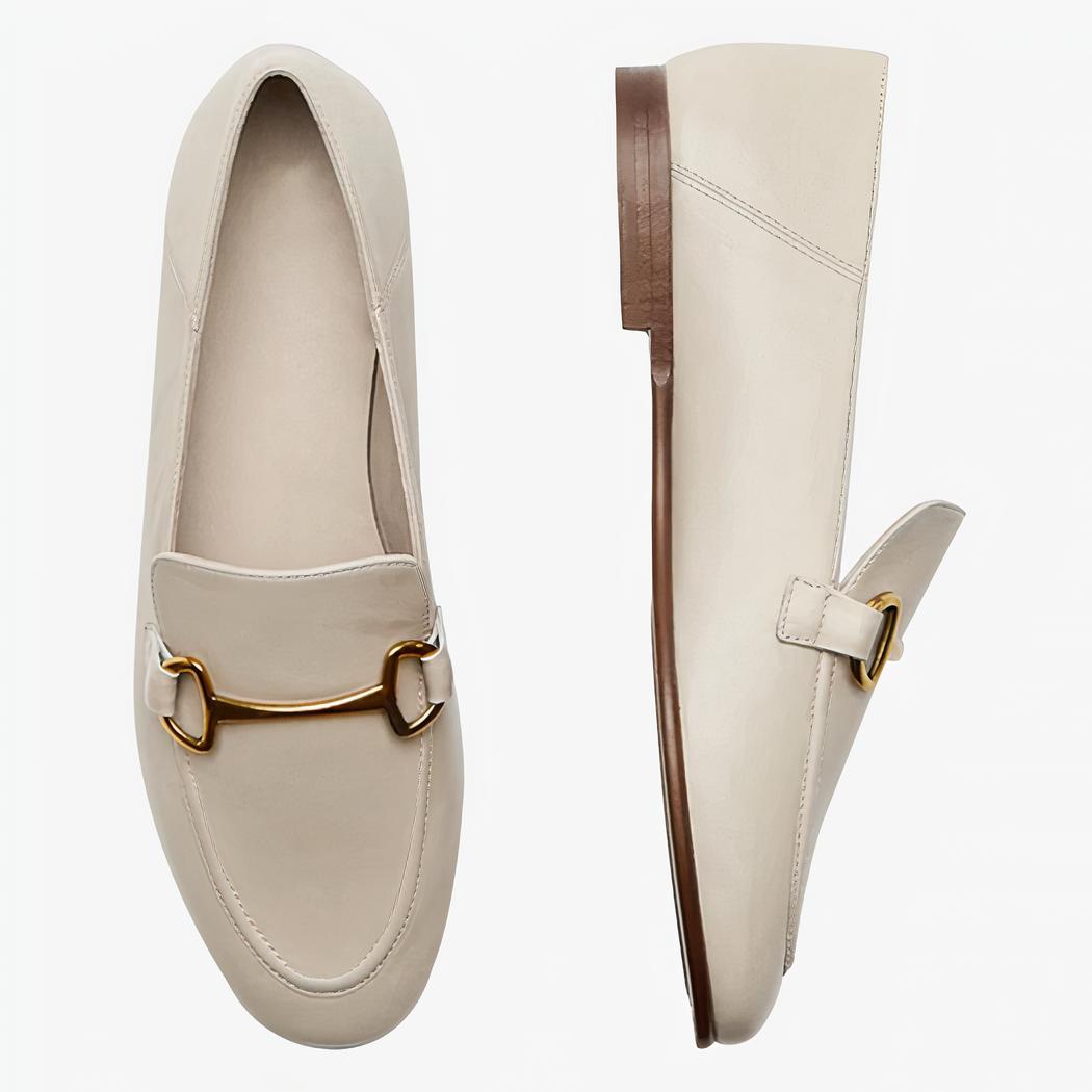 På en ljus bakgrund syns ett par beigea tunna och lätta loafers i äkta läder
