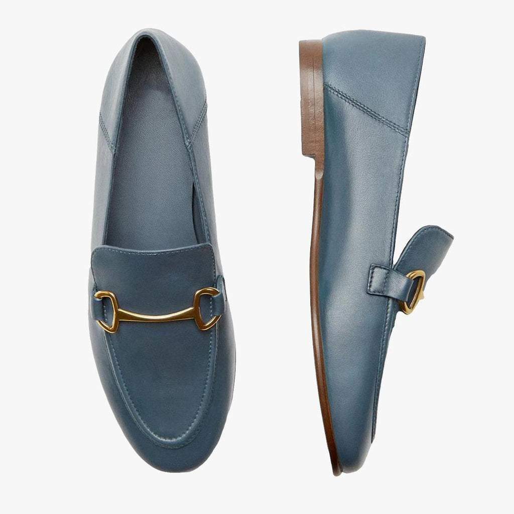 På en ljus bakgrund syns ett par blå tunna och lätta loafers i äkta läder