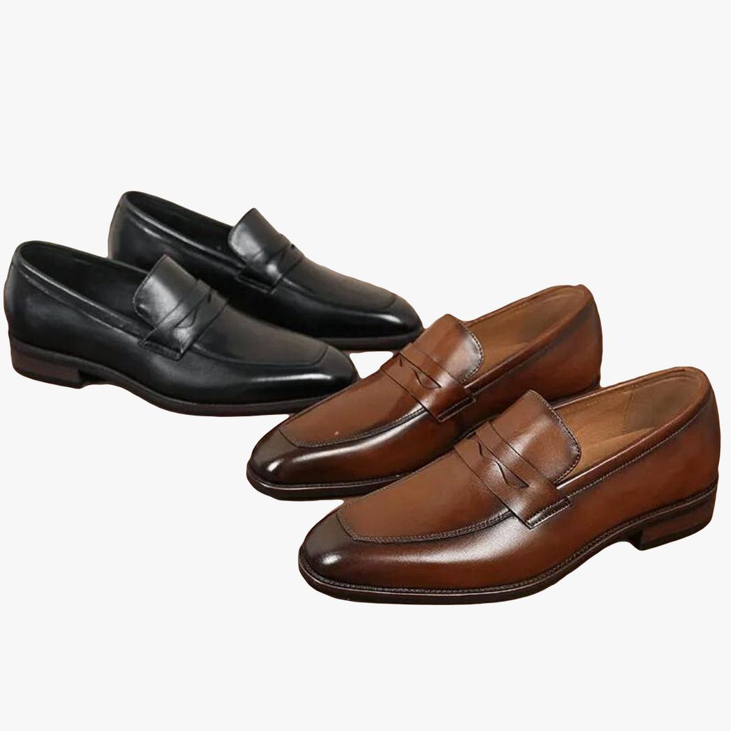 På en brun bakgrund syns två par eleganta loafers i äkta läder för herr, det ena paret är svart och det andra brunt