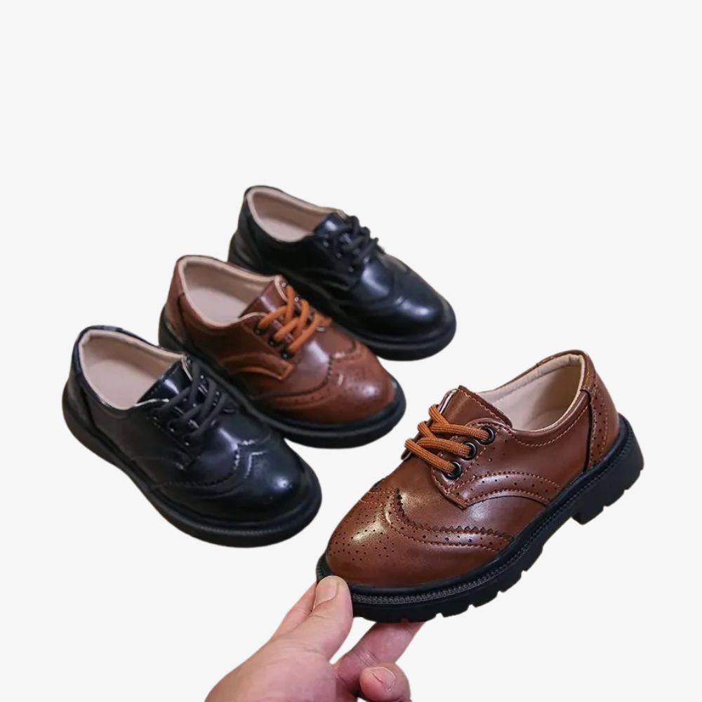 Två par loafers i svart och brunt, där en brun sko hålls i en hand.