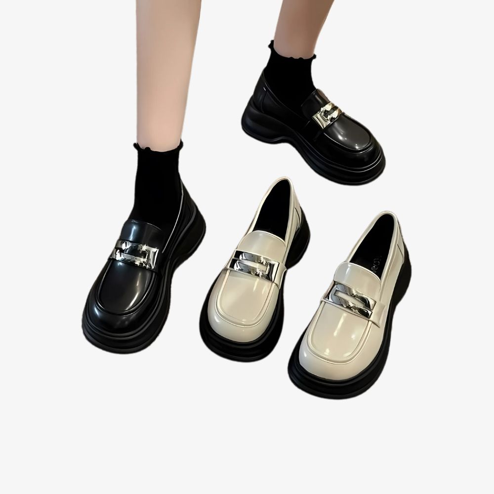 Kvinnoben i svarta platåloafers, med ett par av samma modell i beige bredvid