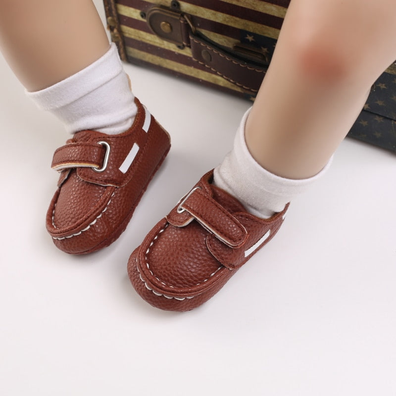 Baby med vita strumpor och bruna mockasiner i båtmodell