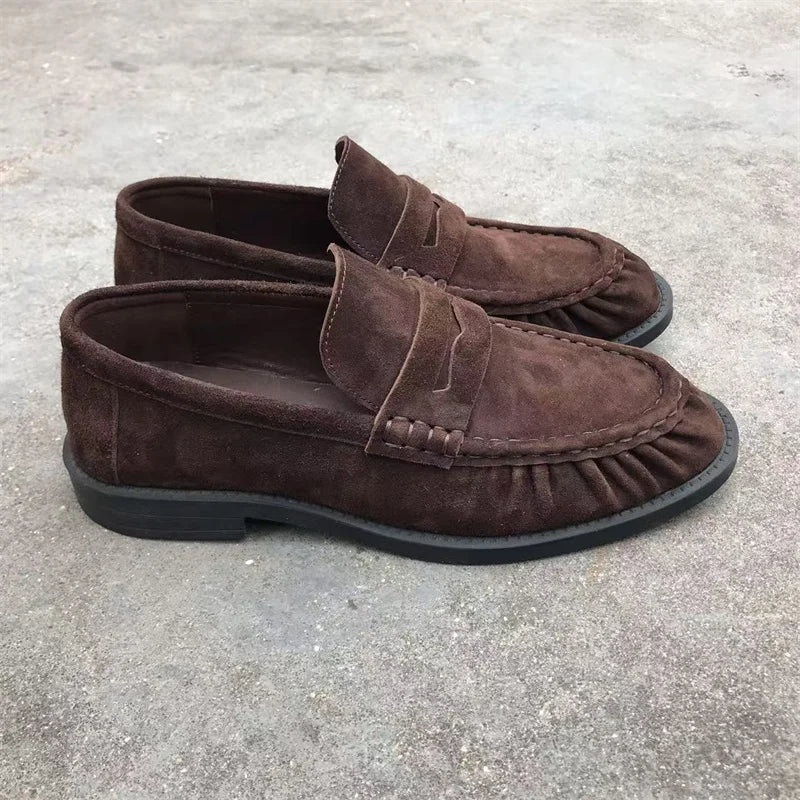 Bruna loafers för dam i mockalook med veckade sömmar buren på foten