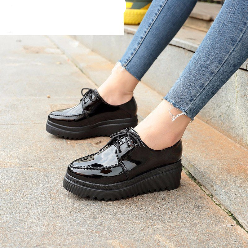 kvinna i svarta kilklackade loafers