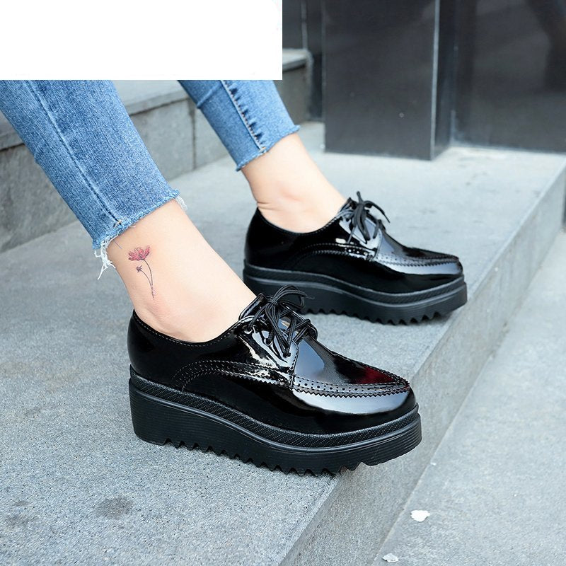 svart patent dam wedge loafer som bärs av en kvinna