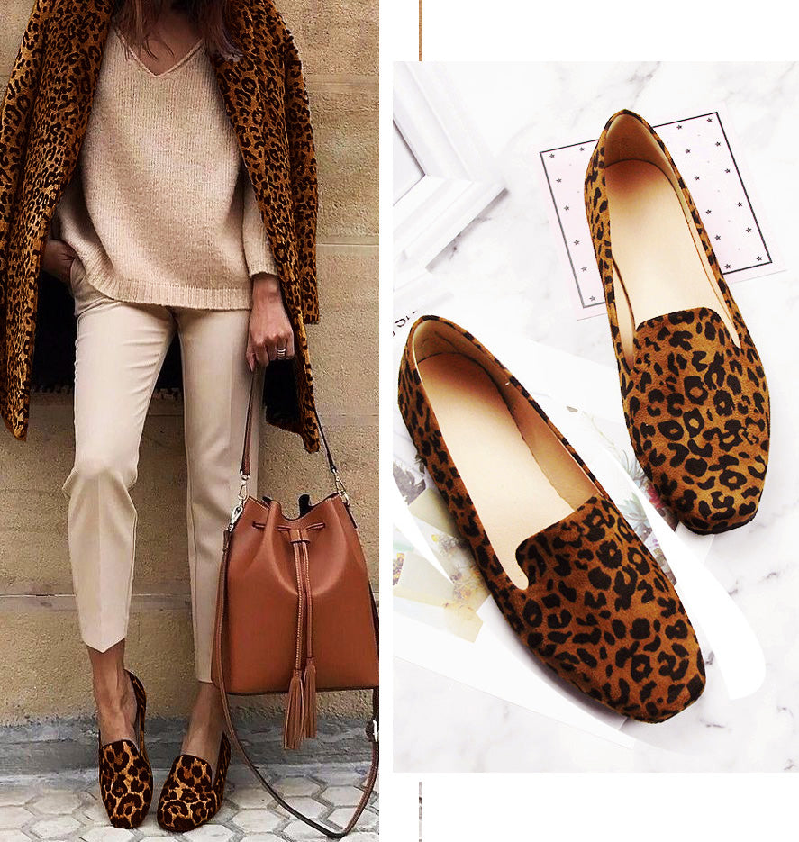 stående kvinna klädd i beige med en väska i handen och leopardmockasiner