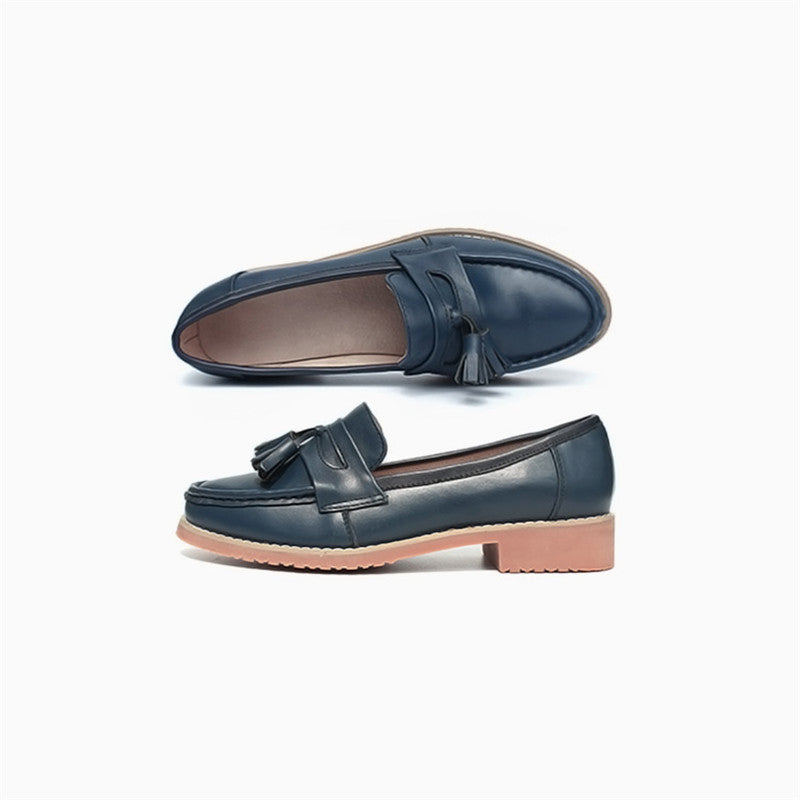 Beige loafer med tofs i profil mot en vit bakgrund