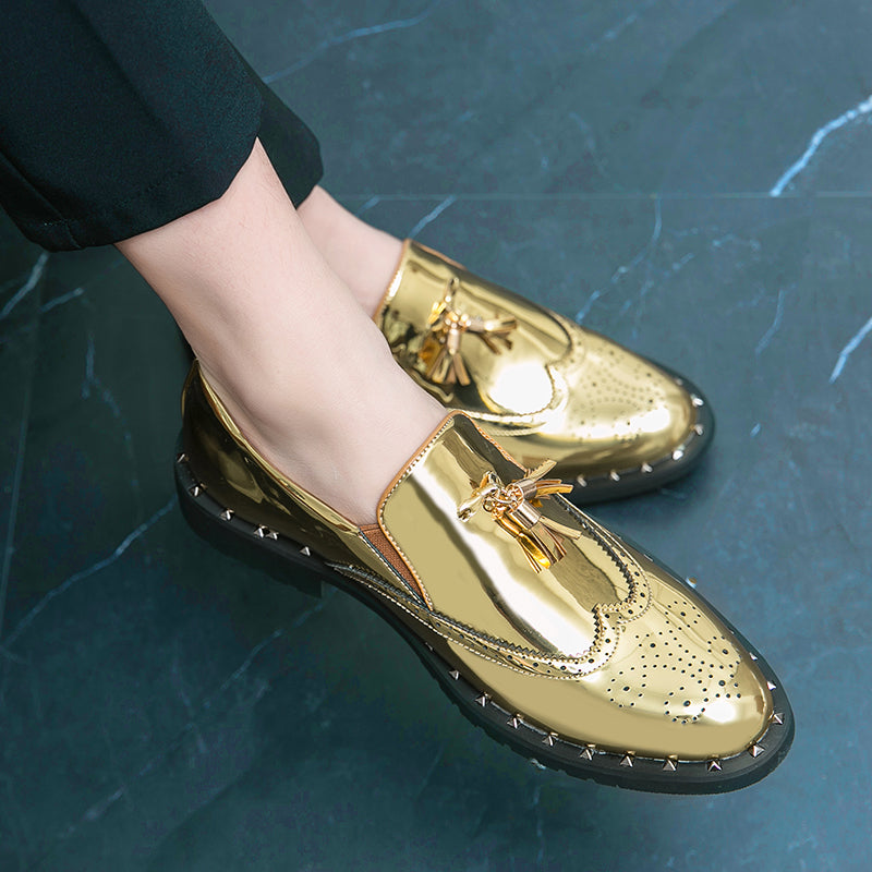 Eleganta guldfärgade loafers för män med en svart rutig bakgrund