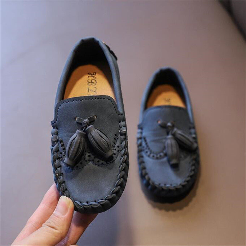 Eleganta loafers med tofs för pojkar med beige bakgrund