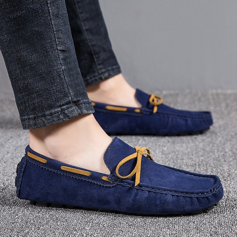 Fot av en man i profil klädd i jeans och klassiska blå båtloafers