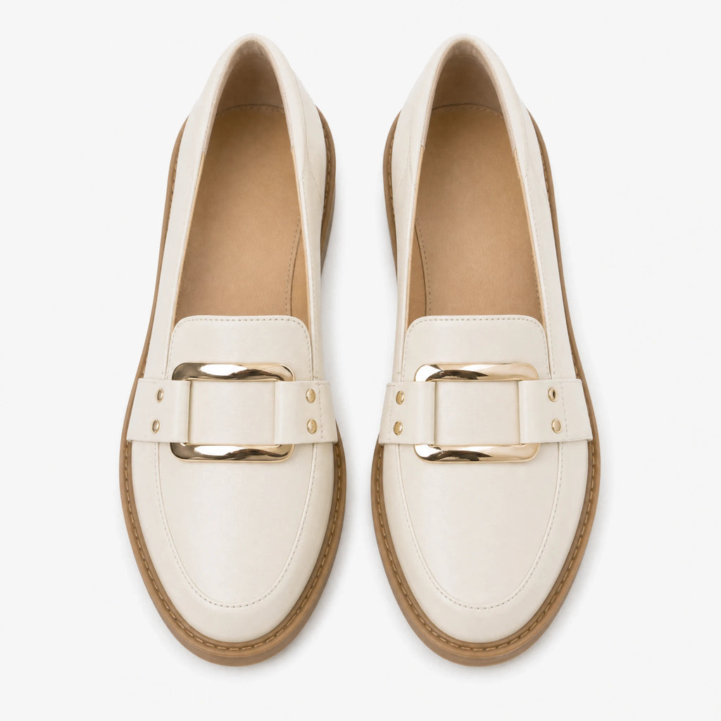 Beige loafers för dam med guldspänne och kamelfärgad sula, framifrån