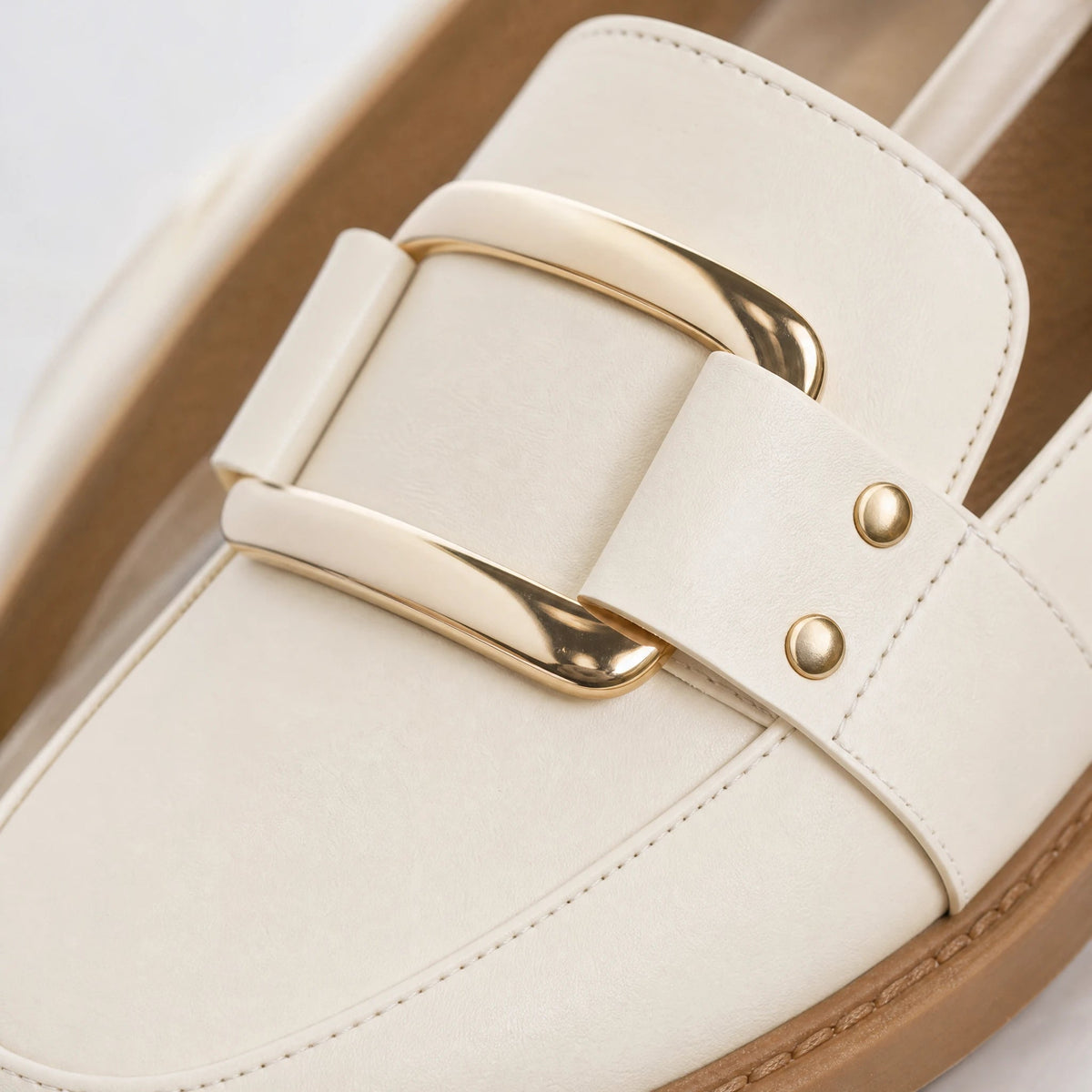 Beige loafers för dam med guldspänne och kamelfärgad sula, från sidan Bild