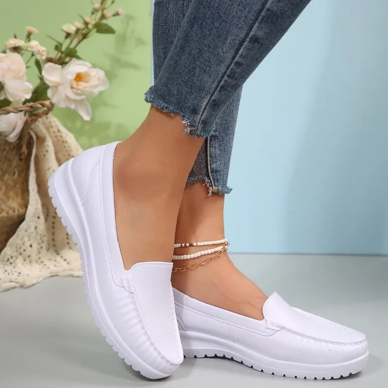 Vita och svarta loafers sida vid sida