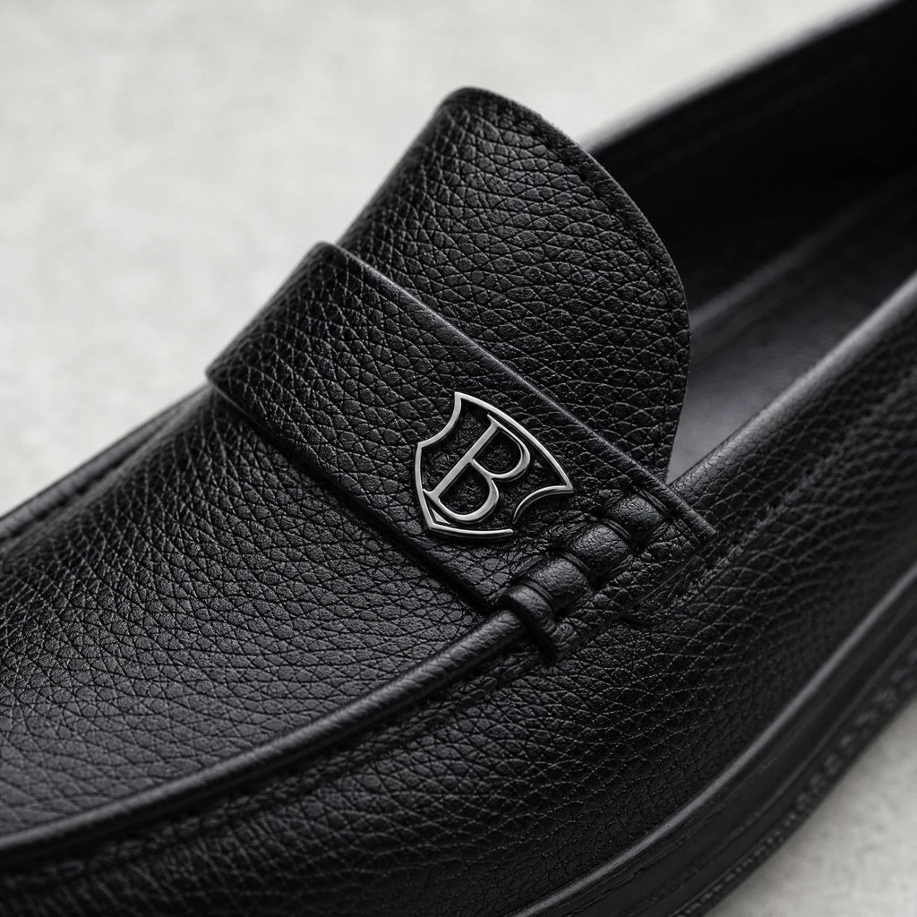 Svarta loafers för herr med tjock sula i kornigt läder, från sidan