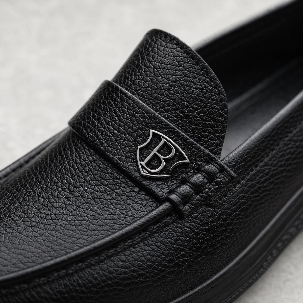 Svarta loafers för herr med tjock sula i kornigt läder, från sidan