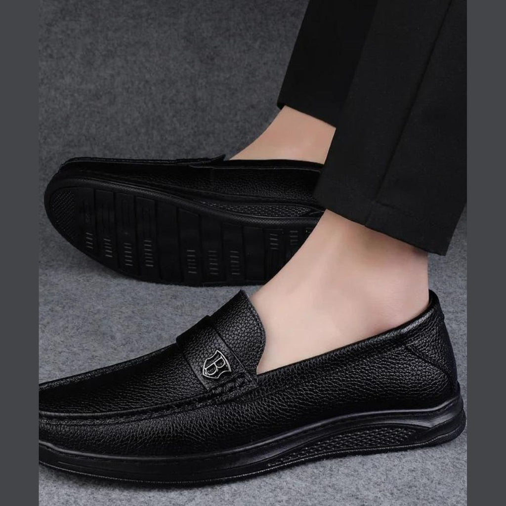 Svarta loafers för herr med tjock sula i kornigt läder, på foten