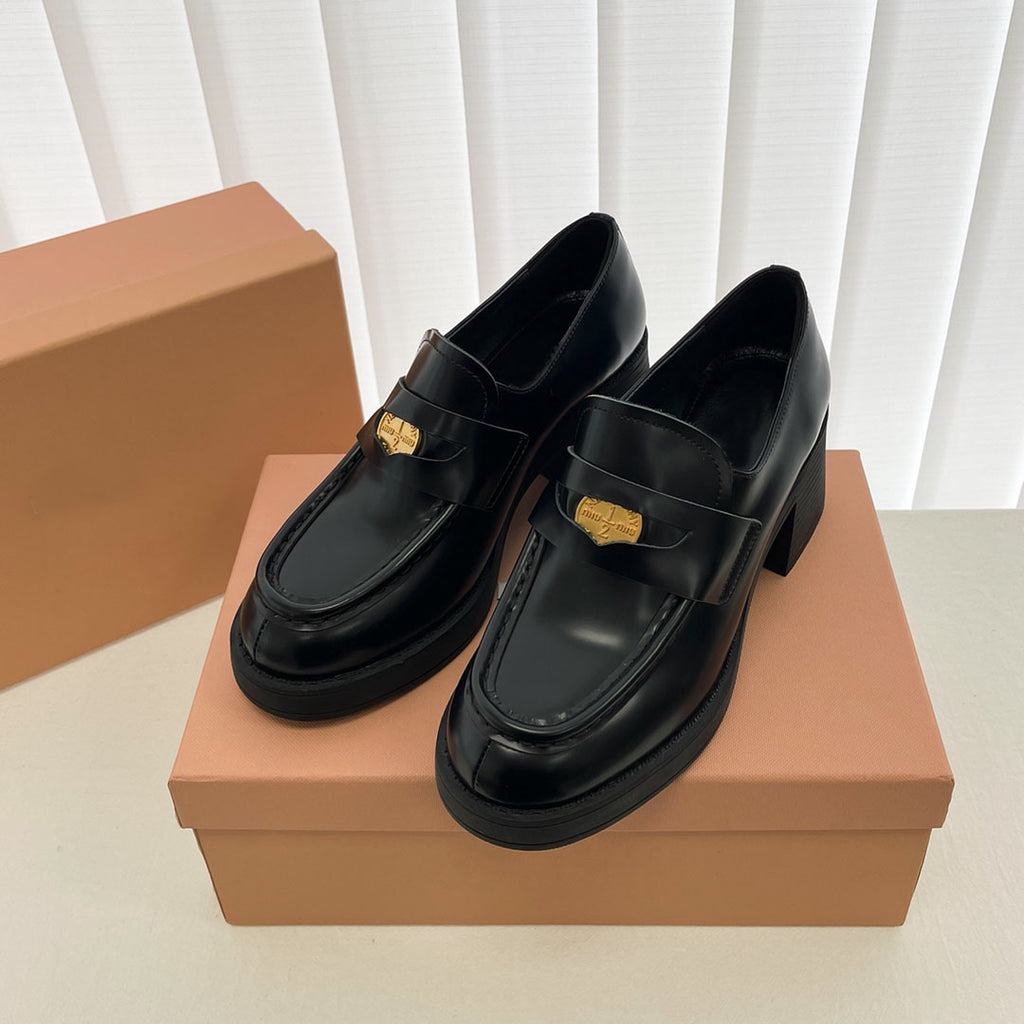 Svarta loafers i en brun skokartong