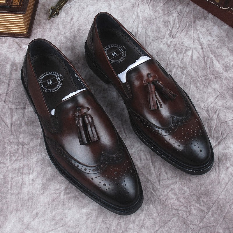 Tassel loafers i brunt äkta läder för män med grå bakgrund