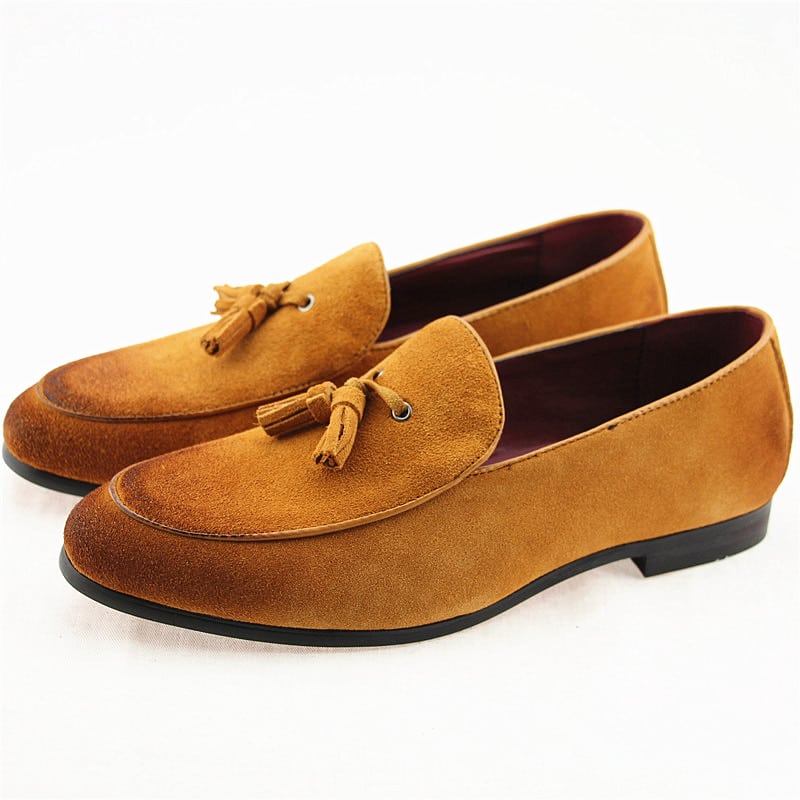 Ett par loafers i brun mocka mot en vit bakgrund