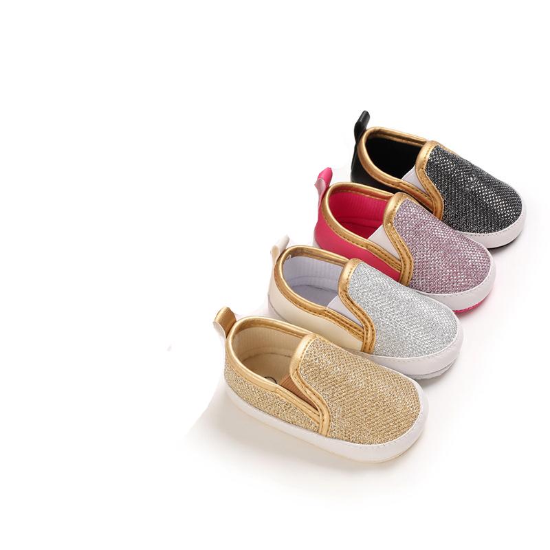 Fyra guld-, silver-, rosa- och svarta loafers uppradade diagonalt