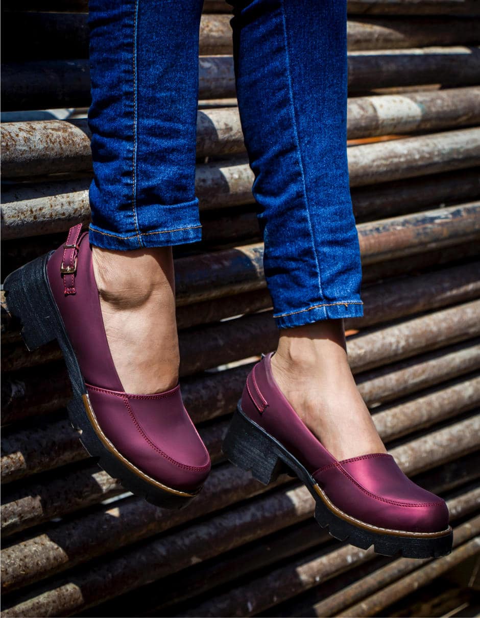 Vinröda damloafers med klack, burna till jeans Bild