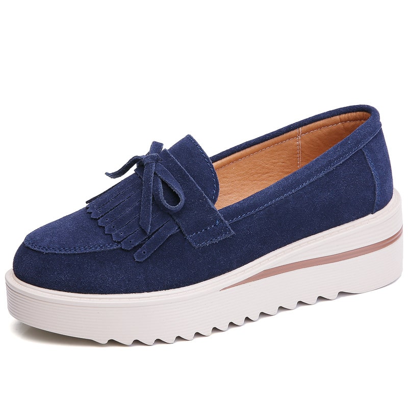blå mocka wedge tassel loafer med vit sula mot en vit bakgrund