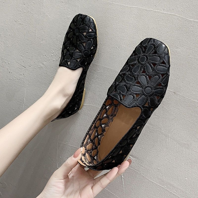 Platta mjuka svarta loafers med genombruten design och blommönster