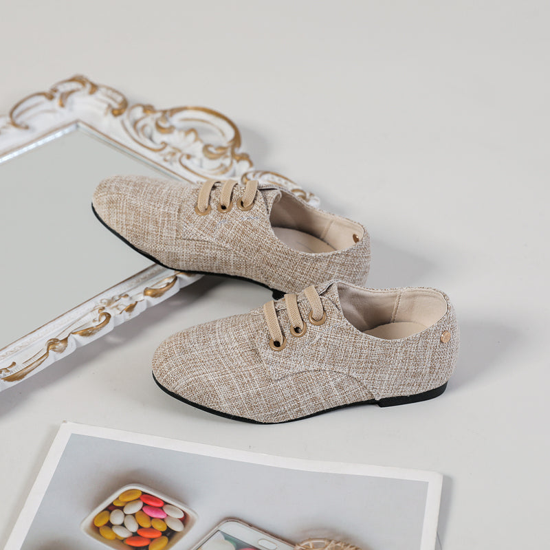 Slip-on-mockasiner för pojkar i neutralfärgat tyg med beige bakgrund, spegel och affisch