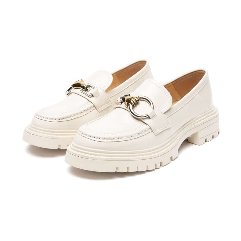 Foto av ett par beige loafers mot en vit bakgrund
