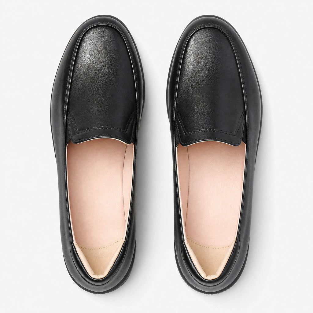 Svarta loafers för dam med kilsula sedda snett framifrån
