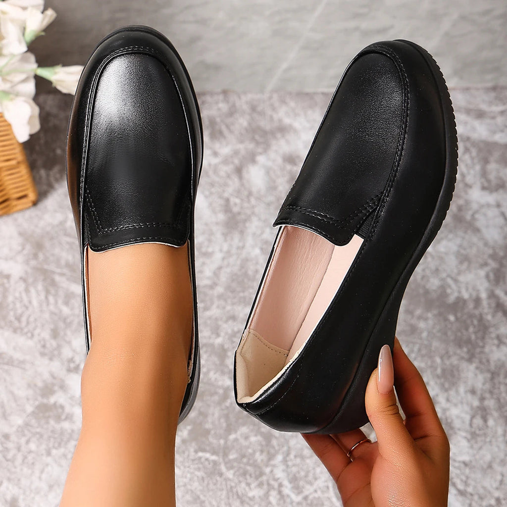 Svarta loafers för dam med kilsula från sidan