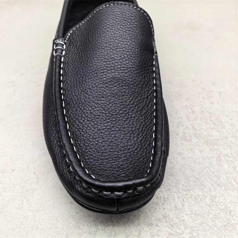 Svarta slip-on loafers för herr med vita kontrastsömmar ovanifrån