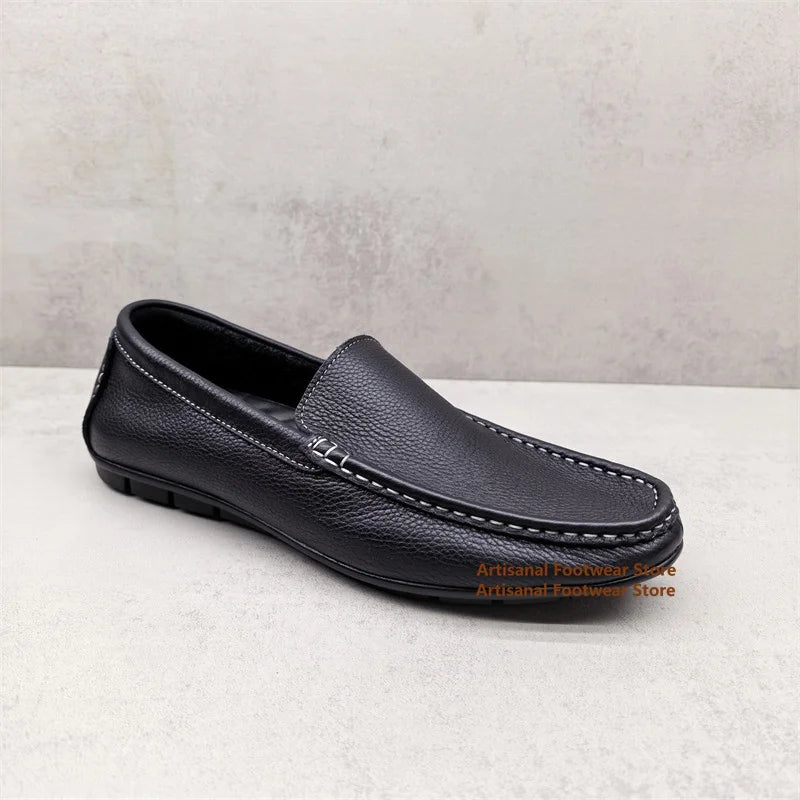 Svarta slip-on loafers för herr med vita kontrastsömmar buren på foten
