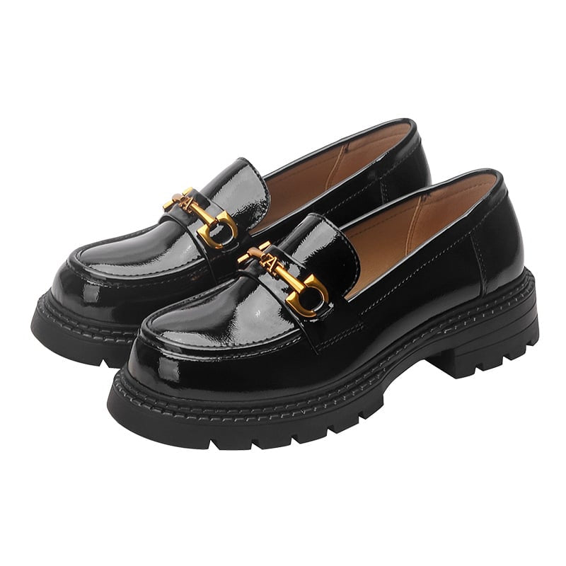 Foto av ett par svarta loafers i lackskinn mot en vit bakgrund