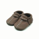 brun babymockasin i läder med synliga vita sömmar