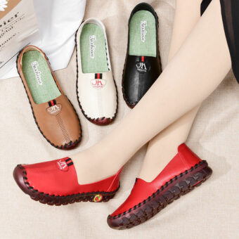 Korslagda ben med röda skor på fötterna tillsammans med andra bruna, svarta och vita skor.