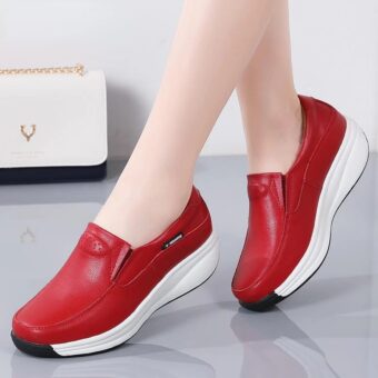 Ett par fötter i röda skor med vita sulor