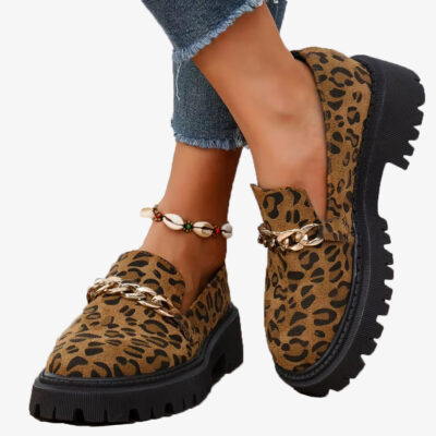 Par loafers i leopardmönstrad mocka med platåsula och kedja, burna med jeans och ett snäckarmband vid fotleden