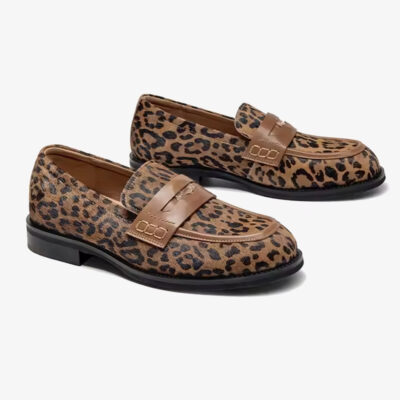 Par loafers i leopardläder med rem över vristen på vit bakgrund